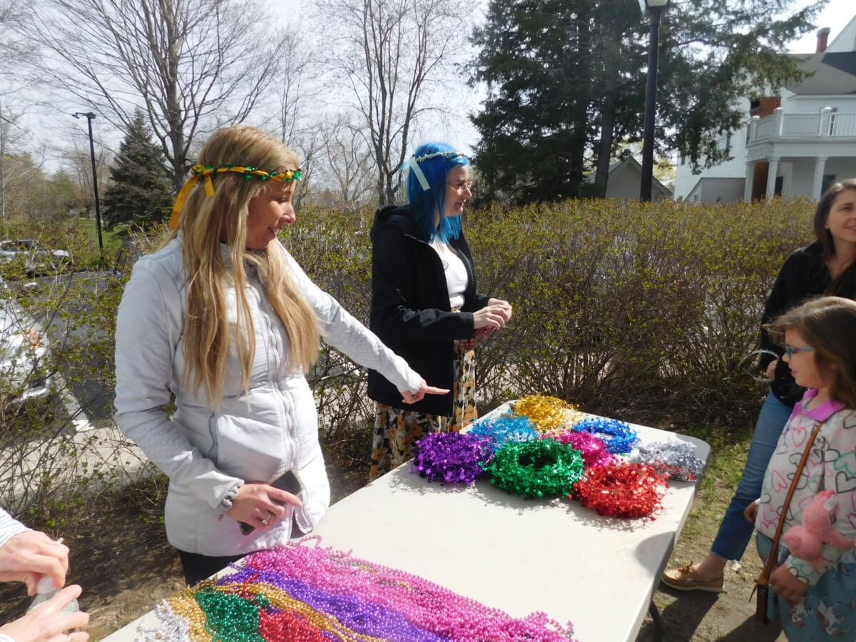 A volunteer helps young patrons assemble crowns at KFL's Faerie Festival
